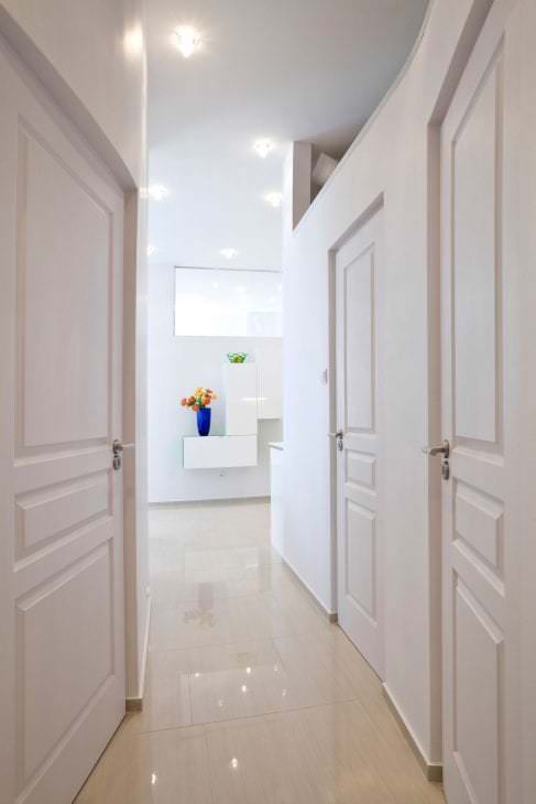 Белые двери в коридоре с глянцевым полом