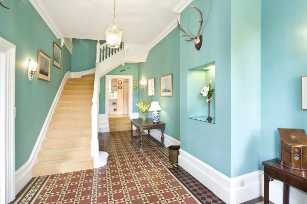 Коридор с плиткой, голубыми стенами и лестницей