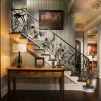 дизайн лестницы в доме с коваными перилами