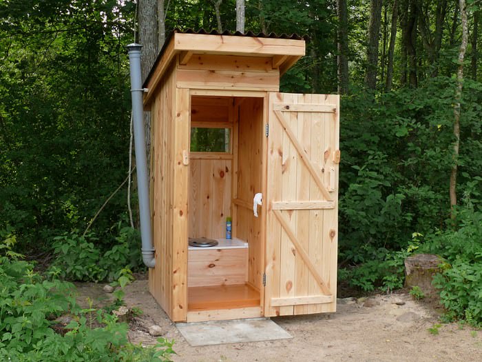 Уличный деревянный туалет с открытой дверью