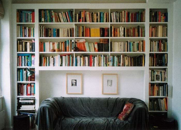 Мини-библиотека над диваном в гостиной