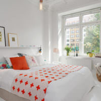 Белая спальня и оранжевая подушка