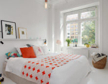 Белая спальня и оранжевая подушка