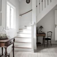 Белая лестница в прихожей жилого дома