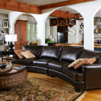 Темно-коричневый диван в интерьере гостиной частного дома
