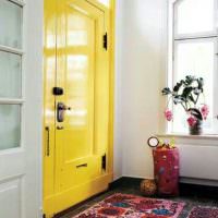 Пестрый ковер перед желтой дверью в прихожей