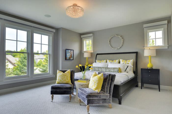 Желтые декоративные подушки в интерьере серой спальни