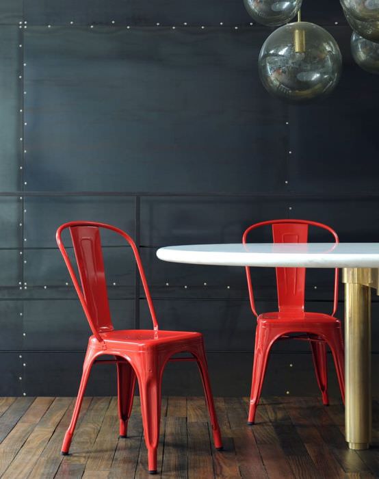 Два красных стула на фоне черной стены