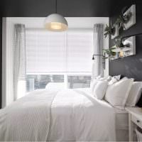 Белая кровать в комнате с серыми стенами