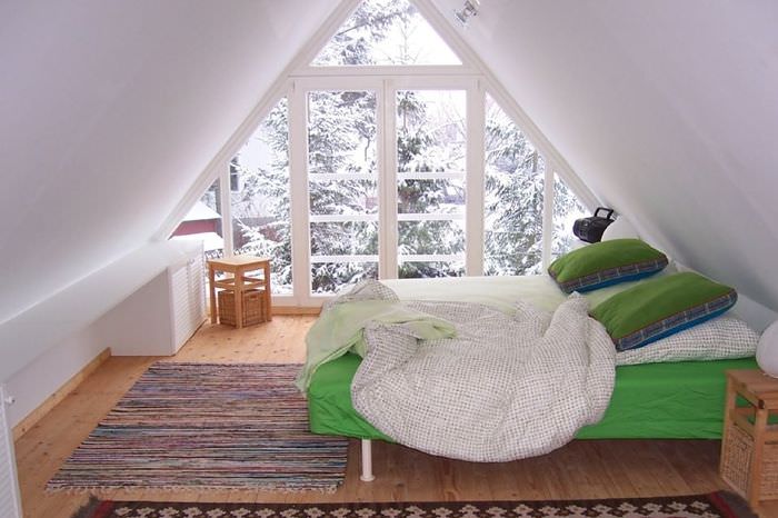 Зеленая кровать в спальне на мансарде