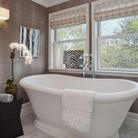 Белая ванна в комнате с серыми стенами