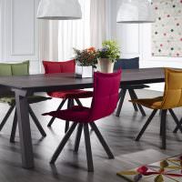 Мягкие стулья разного цвета в столовой-кухне частного дома