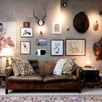 Старый диван возле серой стены с фотографиями