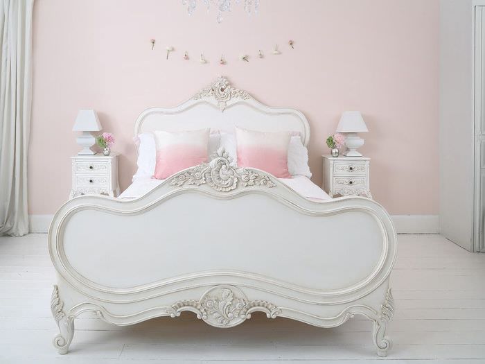 Интерьер белой спальни с розовой стеной