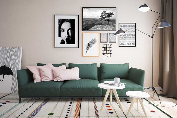 Украшение фотографиями стены над темно-зеленым диваном