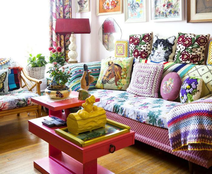 Разномастные подушки на диване с пестрым покрывалом