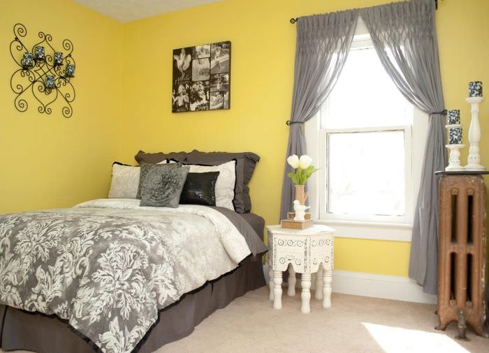 Полупрозрачные занавески серого тона в спальне с желтыми стенами
