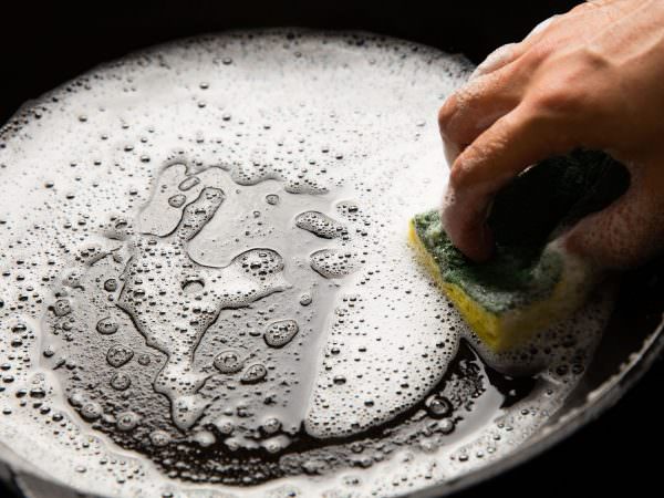 Чтобы очистить противень, нужно залить его горячей водой и добавить туда соду и средство для мытья посуды. 