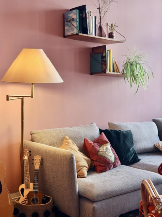 Серый диван на фоне розовой стены